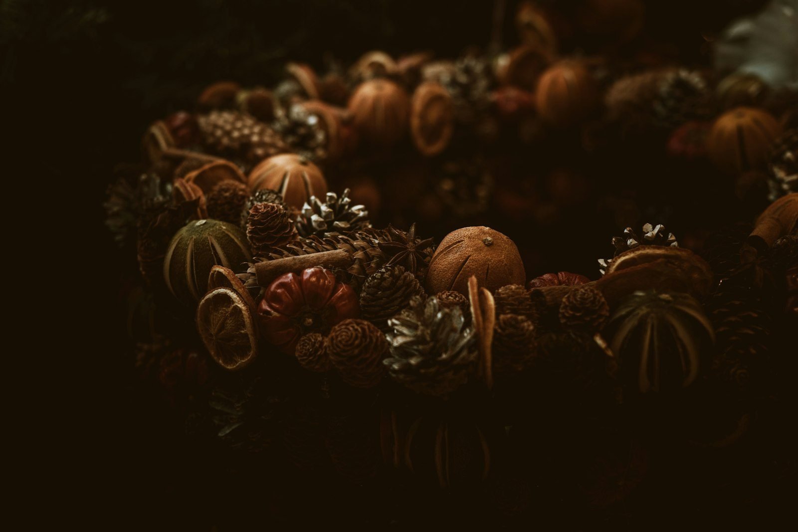 Rustic wreath with dried oranges, pine cones and cinnamon in earthy tones