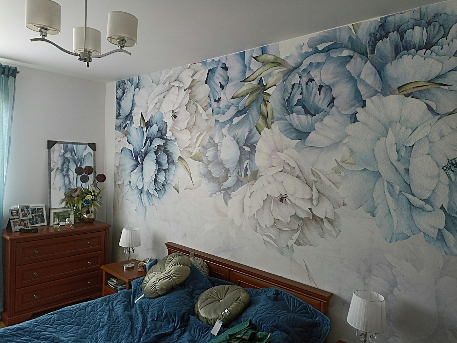 Bedroom with large-scale blue floral wallpaper behind the bed