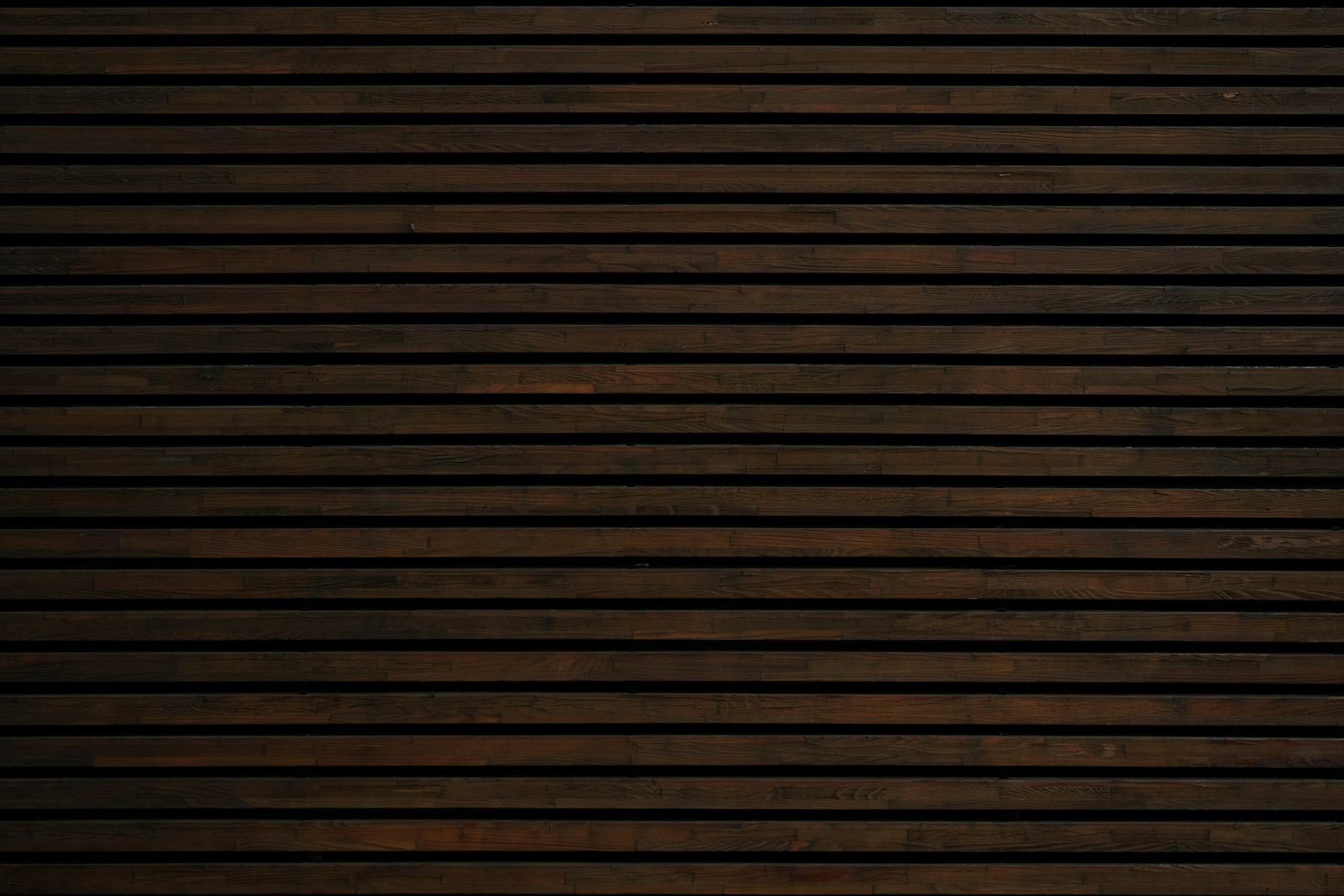Close-up of dark wooden slats laid horizontally with thin grooves between them